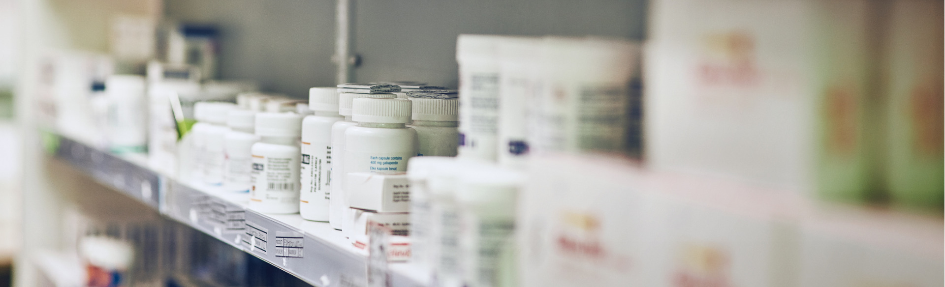various medications lined up on a pharmacy shelf