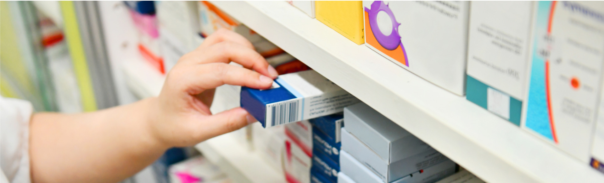 pharmacist taking a medication from a shelf in the pharmacy