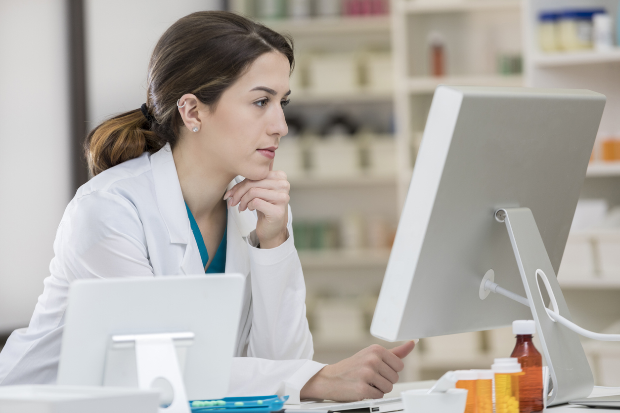female pharmacy employee looking at computer screen