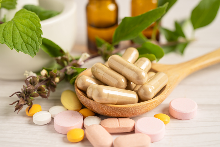 natural vitamins and supplements on a wooden spoon