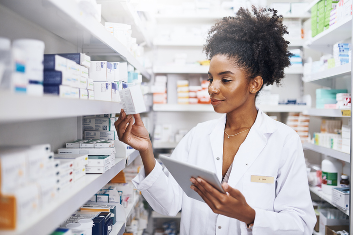 pharmacist checking medication while holding a tablet device