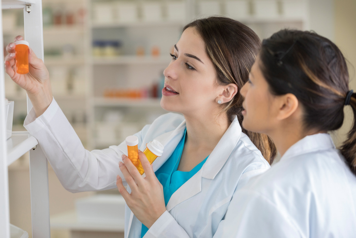 two pharmacists looking at medication in the pharmacy