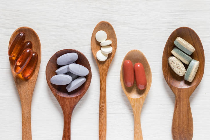 vitamins and supplements on wooden spoons