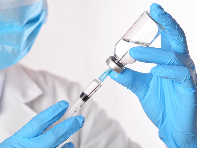 doctor injecting the vaccine with a syringe