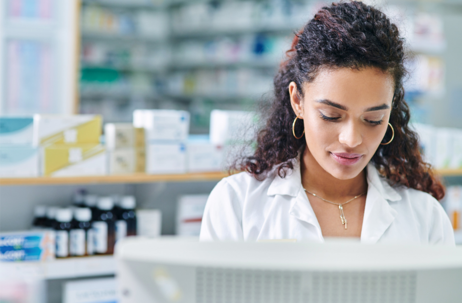 close up of a retail pharmacist working on computer