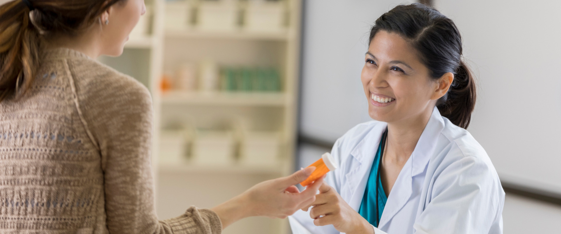 pharmacy technician talking to a patient about their prescription