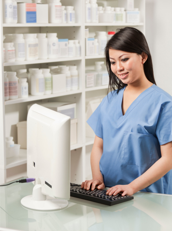 pharmacy technician working on a computer in a retail pharmacy