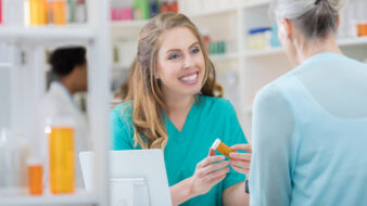 female technician talking to customer in pharmacy