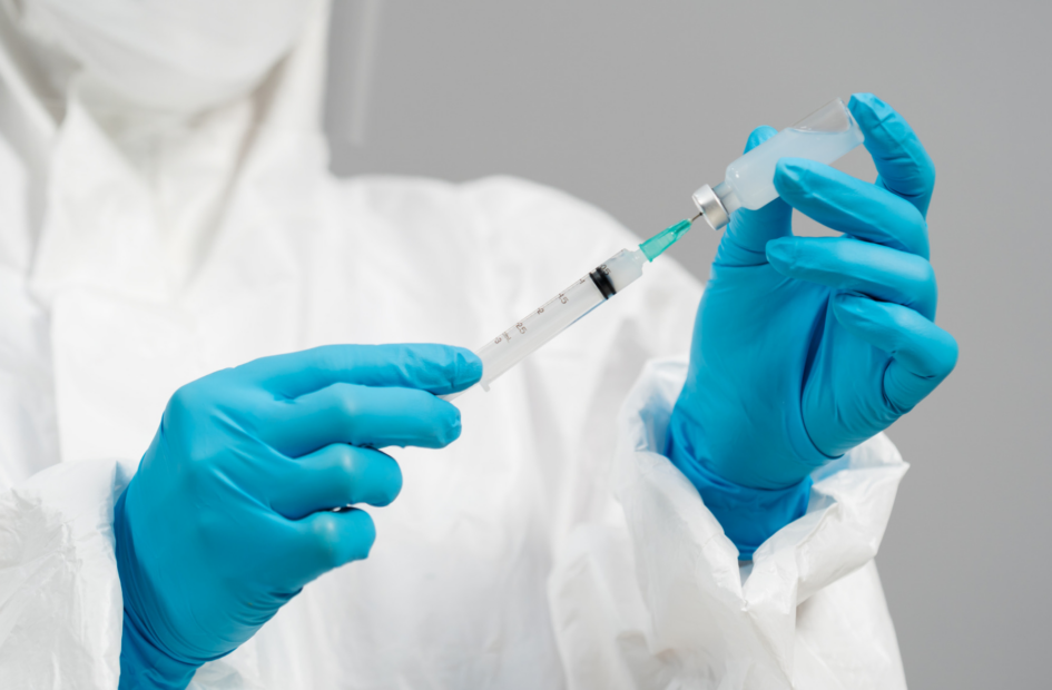 pharmacist drawing vaccine bottle into syringe injection following policies and procedures