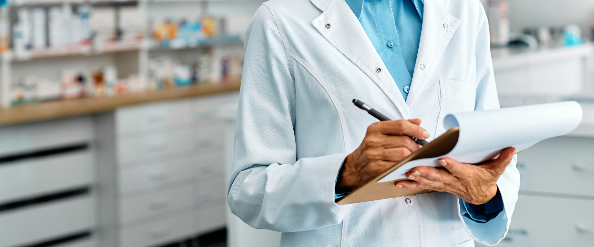 close up of a pharmacist writing on a clipboard
