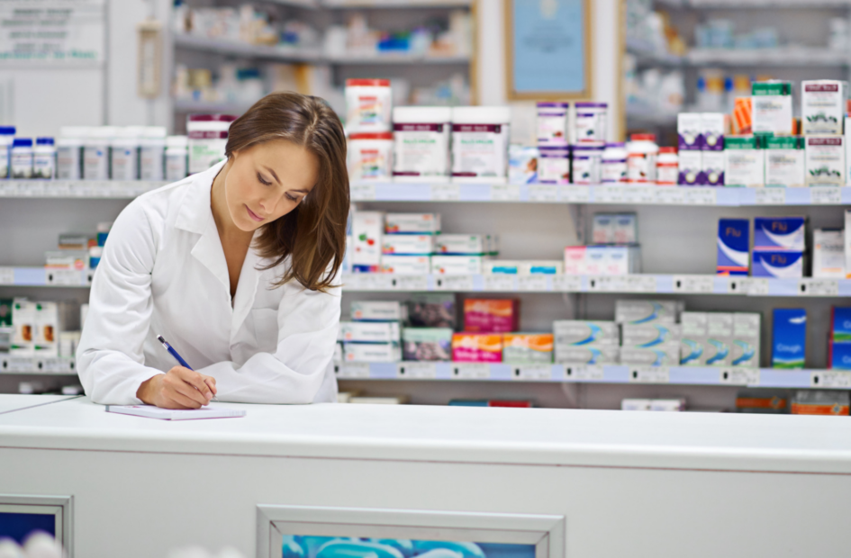 retail pharmacist checking pharmacy laws on the counter