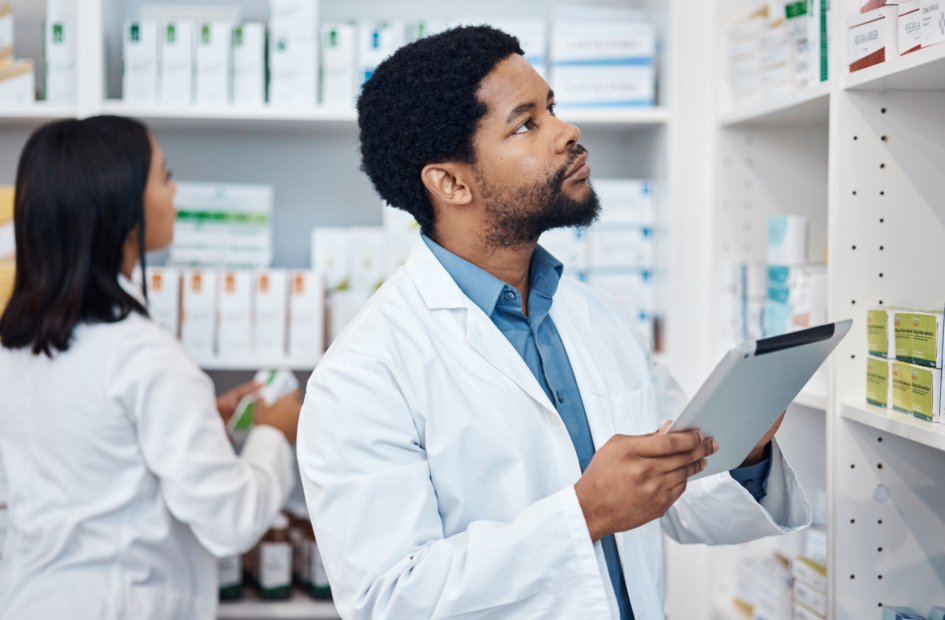 retail pharmacist checking inventory on a tablet device following pharmacy policies and procedures