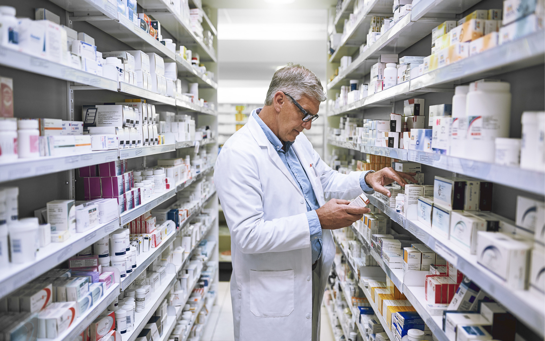 retail pharmacist checking medication in a pharmacy stock room