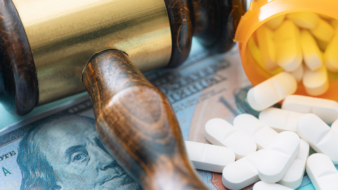 close up of judge gavel, pills, and money