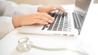 Pharmacist typing on laptop