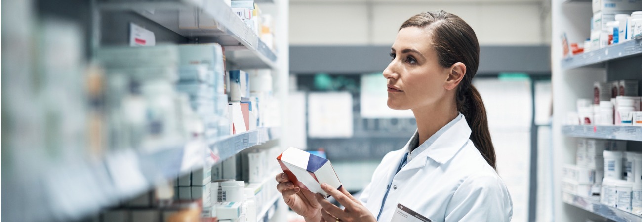 Pharmacist looking at medication in stock room