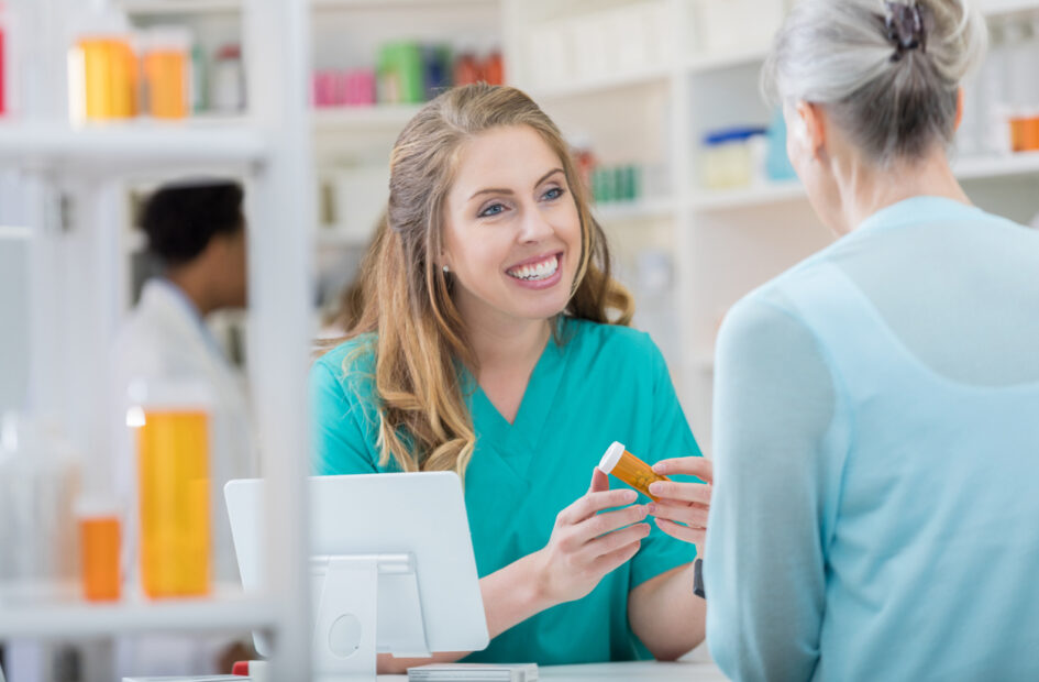 female pharmacy tech talking to older female patient