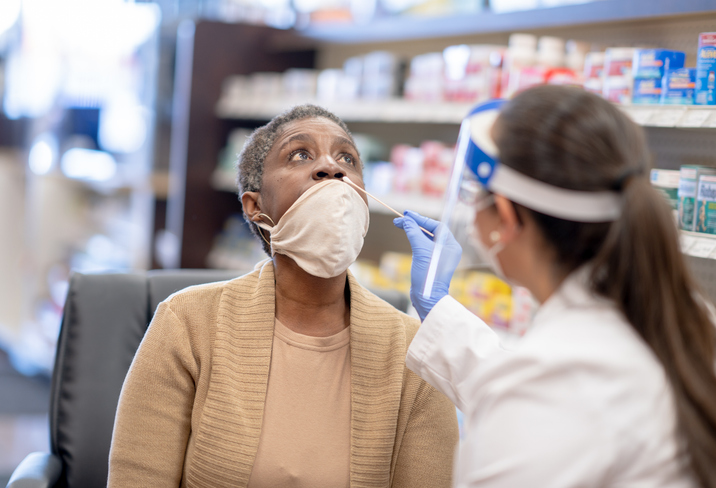 pharmacist testing a patient for covid-19