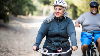 woman and man riding bikes outside on a trail