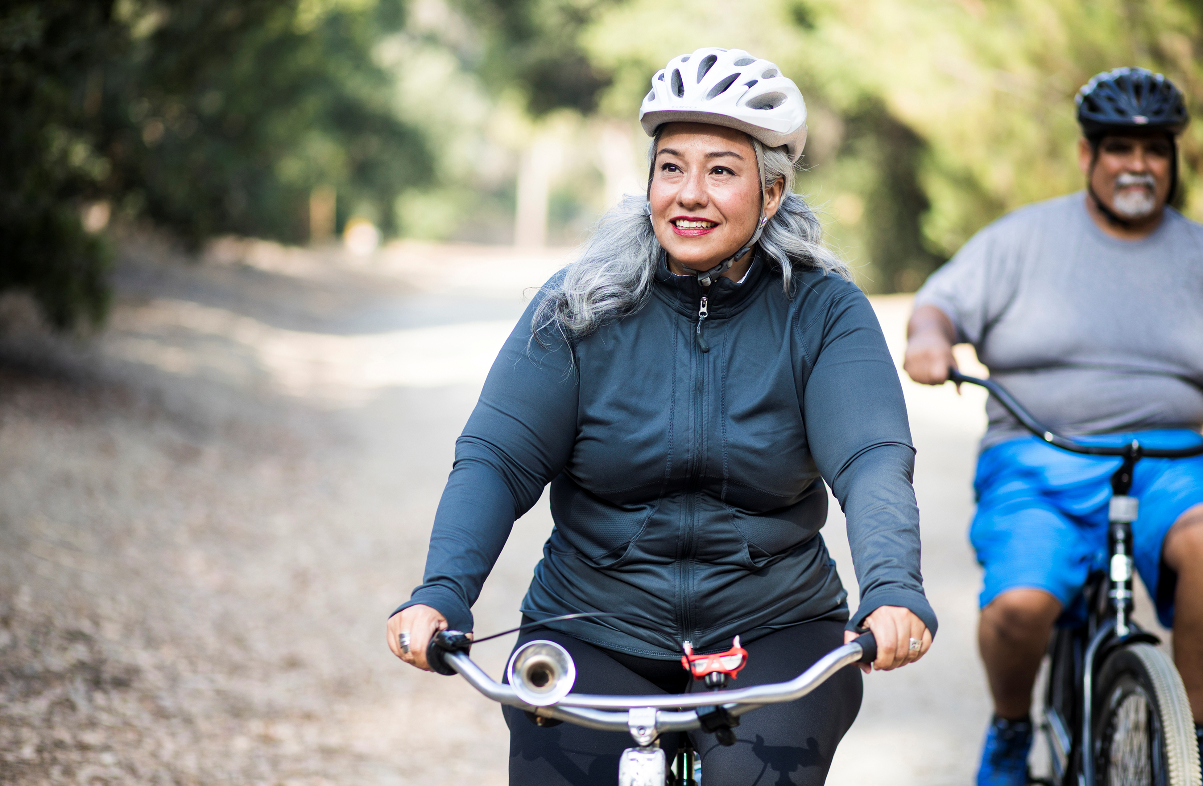woman and man riding bikes outside on a trail
