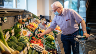 senior man picking fruit at a grocery store