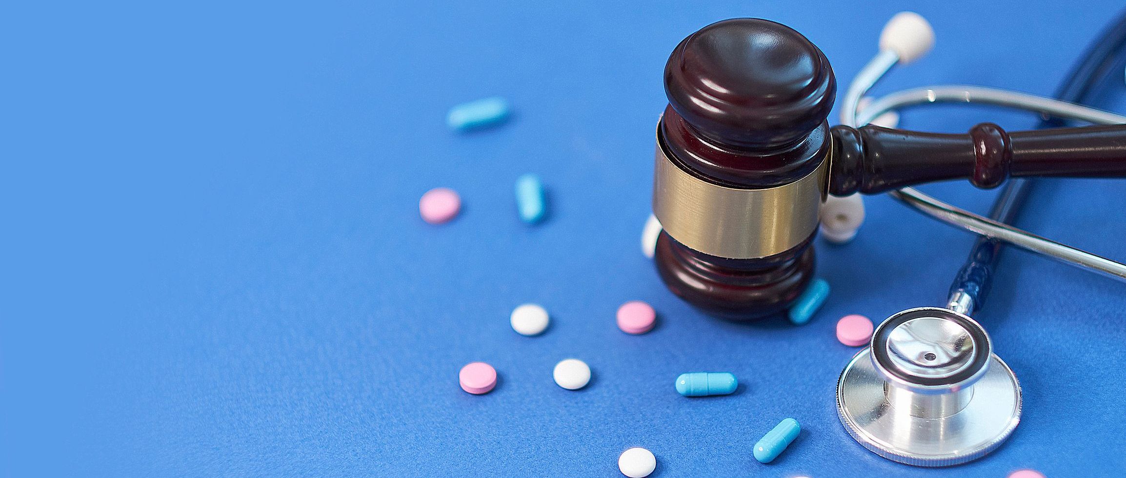 Wooden judge gavel with drugs on table