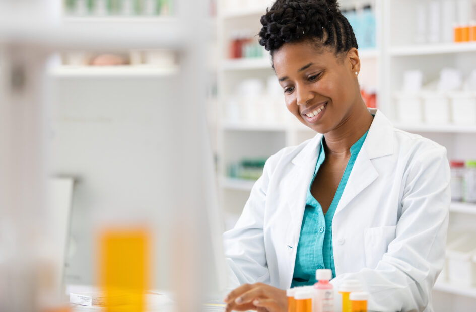young woman on computer in pharmacy