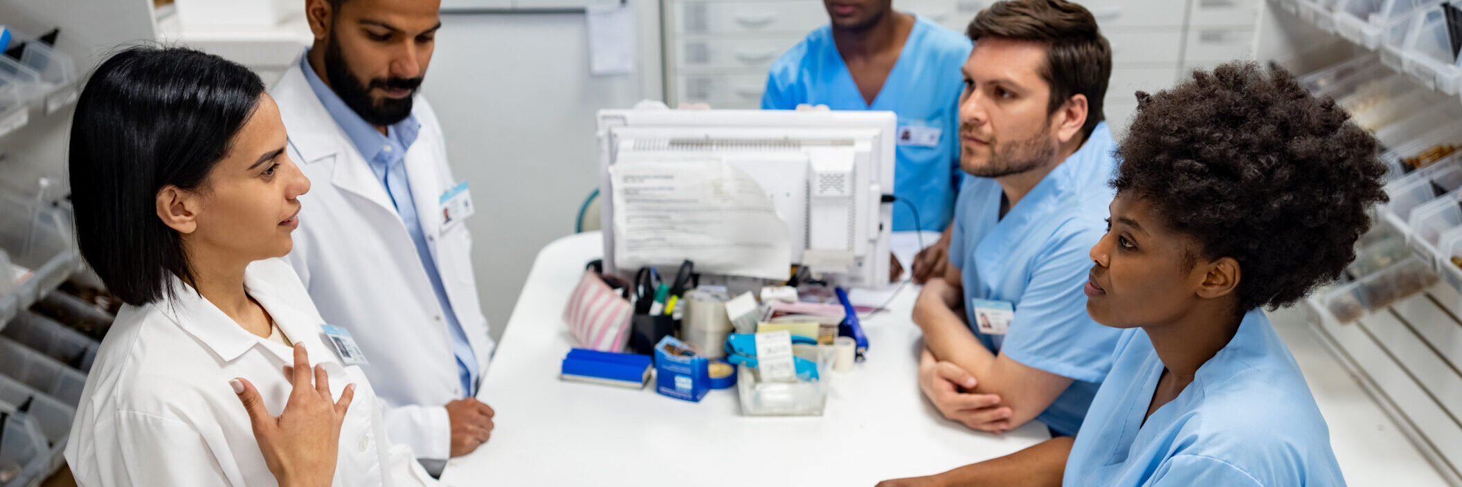 pharmacy staff gathering around desk